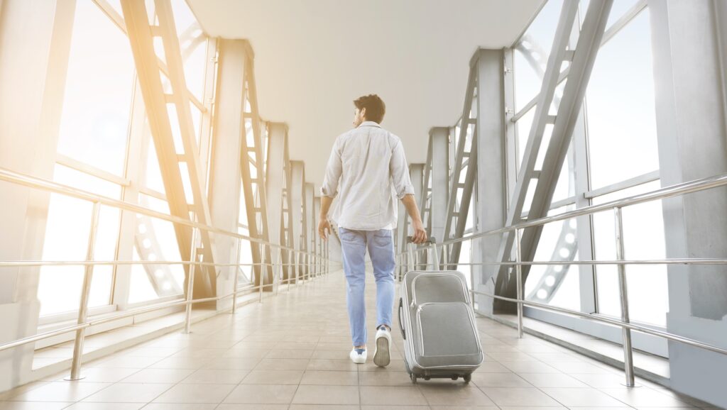 Shows a man walking in the airport with his silver suitcase. This story gives reasons why it's good to travel for drug and alcohol treatment.